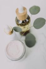 Minimalist skincare display featuring creams and oils with eucalyptus leaves.