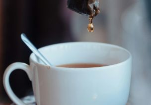 Detailed shot of a tea bag dripping into a cup, highlighting a cozy tea moment.