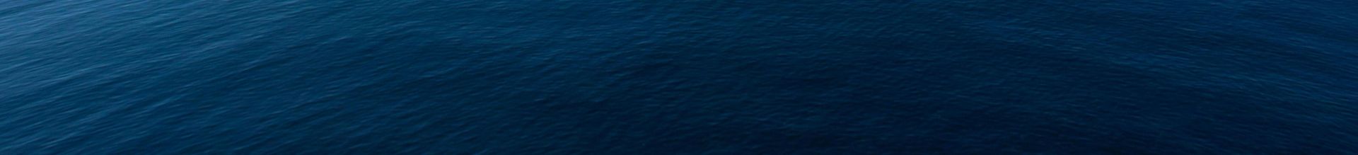 A serene ocean view with a clear blue sky and calm waters, evoking peace and tranquility.