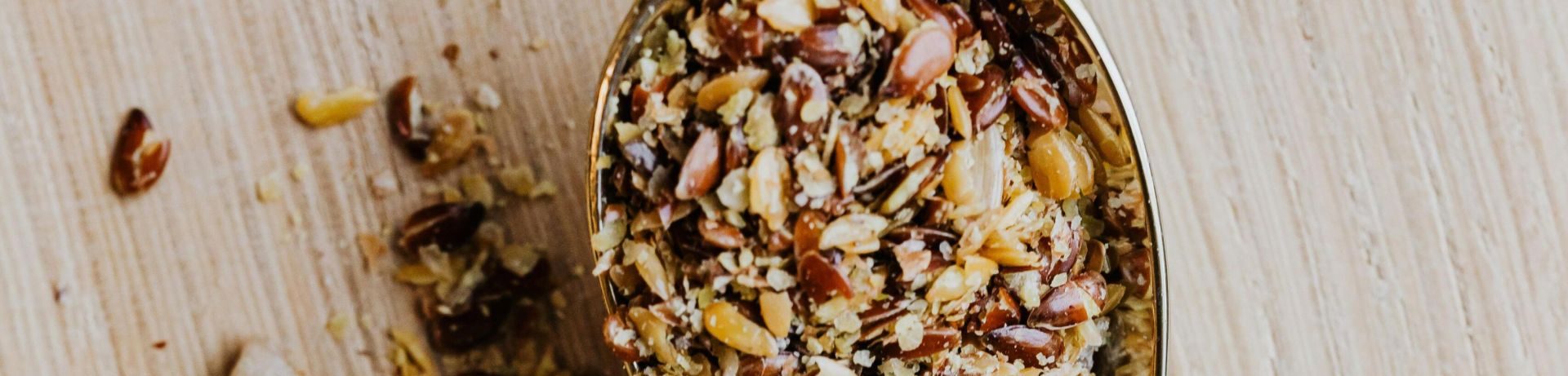 Golden spoon of mixed spices with fresh mint on a wooden surface. Aromatic and natural.